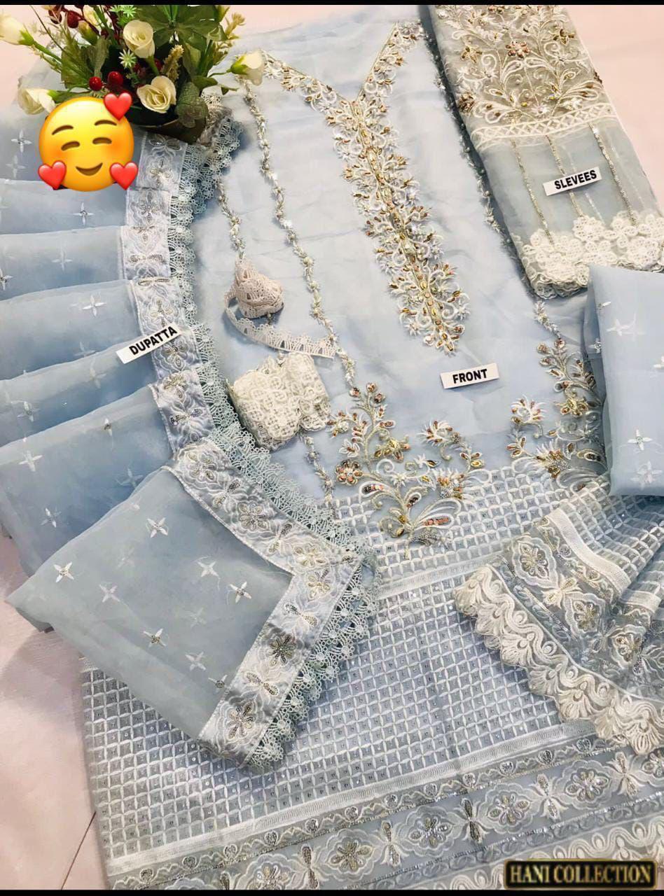 Gray fabric with gold embroidery and jewelry on a pink surface