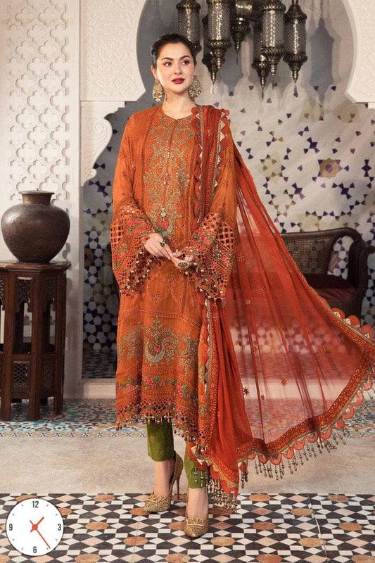 Woman in traditional orange and green outfit with dupatta in ornate interior setting