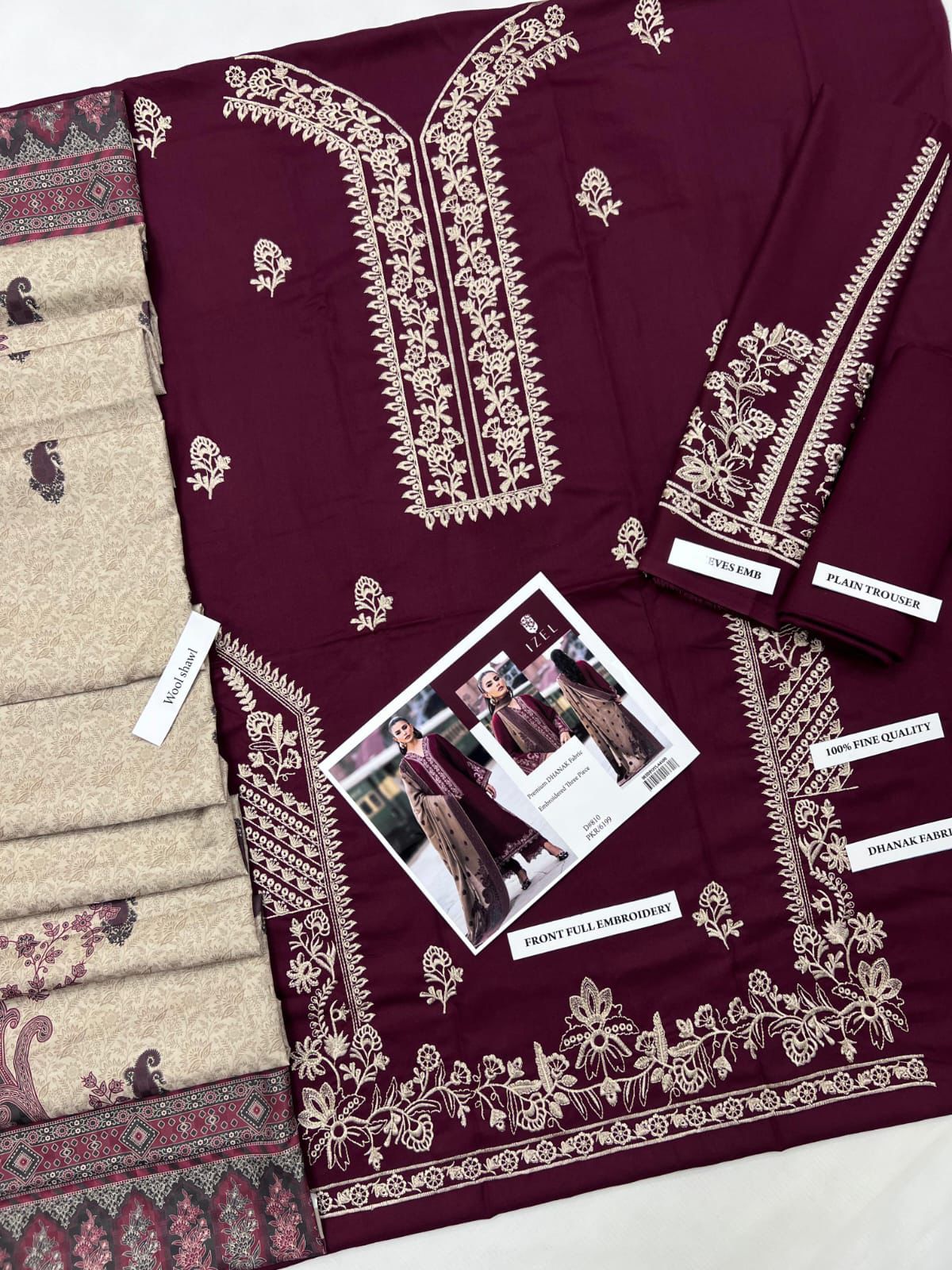 Maroon fabric with intricate white embroidery displayed with a smaller fabric sample and promotional card.