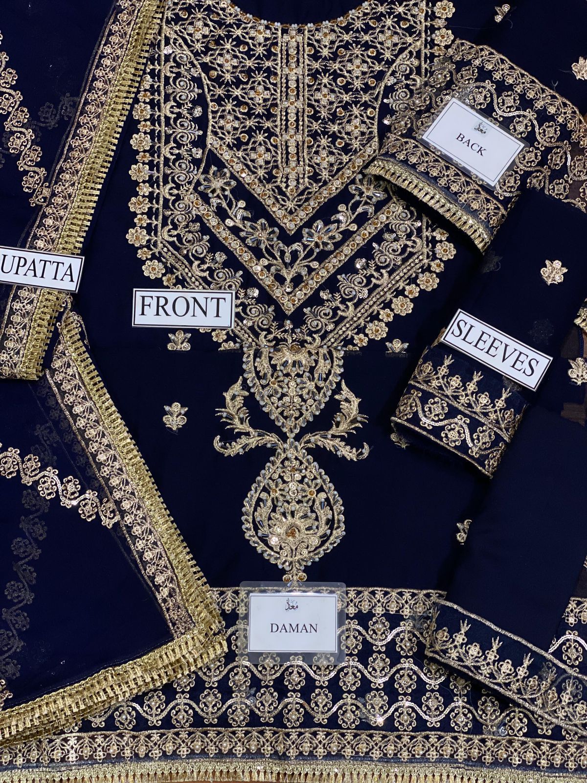 Navy blue fabric with gold embroidery labeled 'Front', 'Uppatta', 'Daman', and 'Sleeves'.