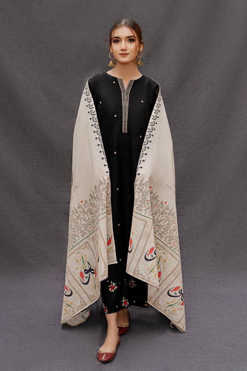 Woman wearing a black outfit with a beige embroidered shawl on a gray background
