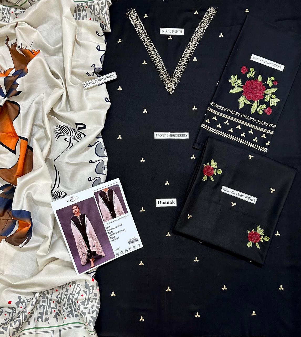 Black embroidered garment with a patterned scarf and leaflet on a white background