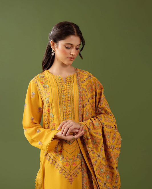 Woman wearing a yellow embroidered traditional outfit against a green background